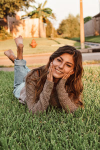 Portrait of young woman sitting on grassy field