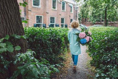 Rear view of woman standing by plants