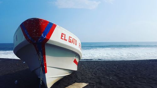 Close-up of text on beach against sky