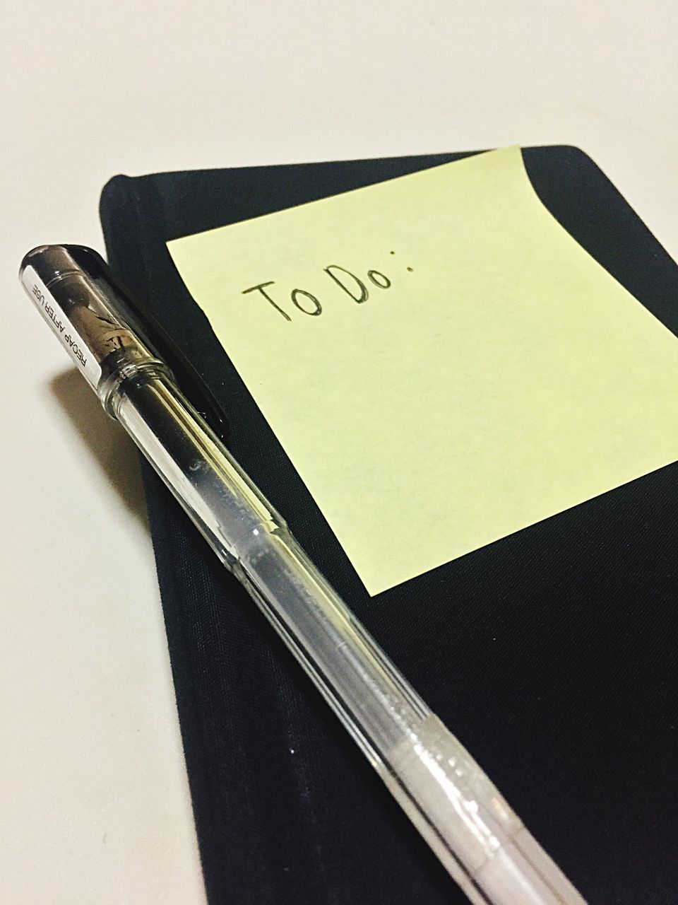 HIGH ANGLE VIEW OF PEN ON TABLE AGAINST WHITE BACKGROUND