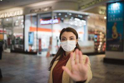 Portrait of woman wearing mask while standing at mall