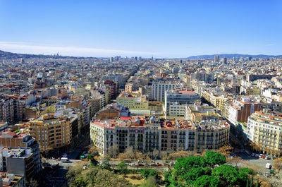 High angle view of buildings in city against clear blue sky