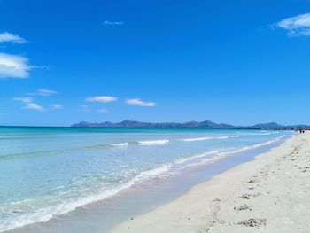 Scenic view of beach against blue sky