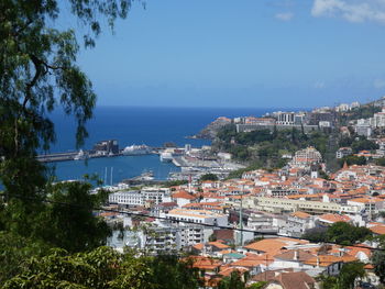 High angle view of townscape by sea against sky