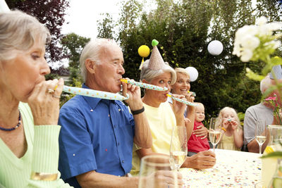 Extended family and friends having birthday party in garden