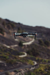 Close-up of a drone above a field against sky