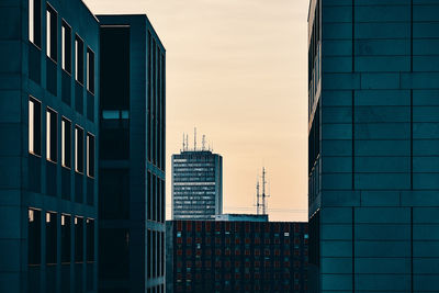 Modern buildings in city against sky during sunset