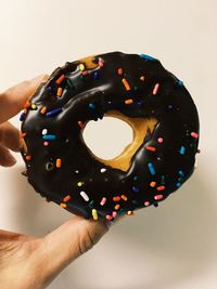 Close-up of hand holding ice cream over white background