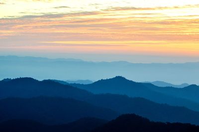 Scenic view of silhouette mountains against sky at sunset