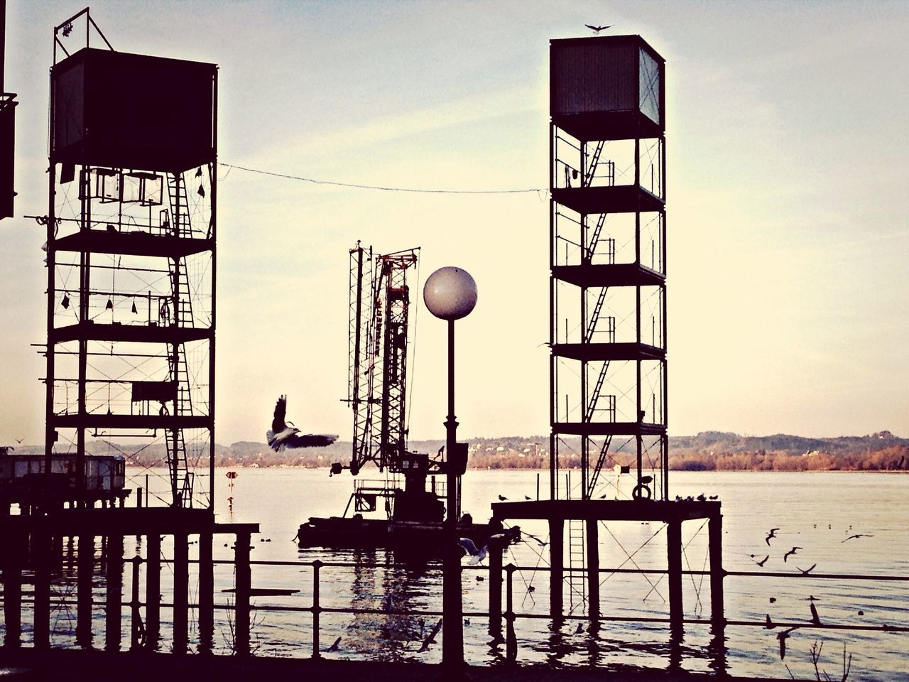 built structure, building exterior, architecture, sky, guidance, lighting equipment, street light, low angle view, sea, lighthouse, water, day, railing, communication, tower, outdoors, no people, lamp post, city, cloud - sky