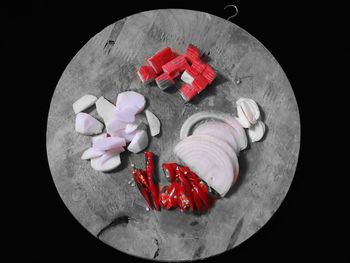 High angle view of red flowers on table against black background