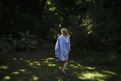 Woman in over sized shirt walking at garden