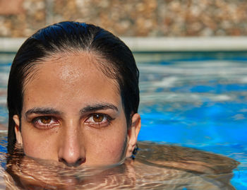 Close-up portrait of young woman in swimming pool