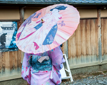 Woman holding umbrella on rainy day