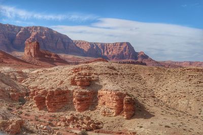 Landscape of orange barren hills and rock formations in marble canyon
