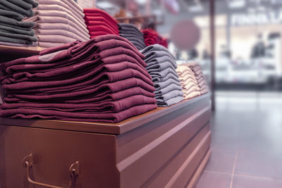 Close-up of stack of clothing on table for sale in store