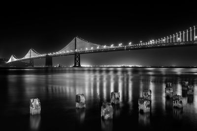 View of suspension bridge over river at night