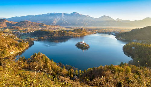 Scenic view of lake and mountains against blue sky