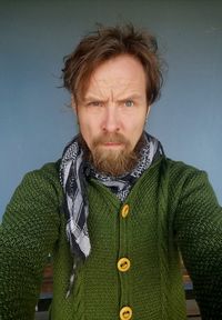 Portrait of man standing against blue background