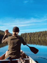 Rear view of woman boating in lake