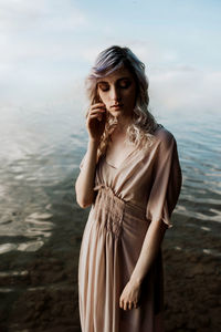 Beautiful young woman standing in water