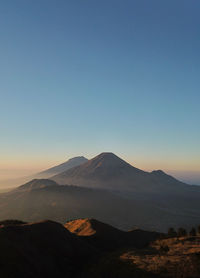 Scenic view of mountains against clear blue sky