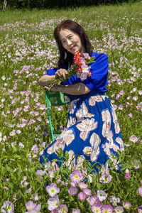 Woman with pink flowers on field