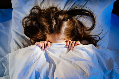 High angle view of girl lying down on bed