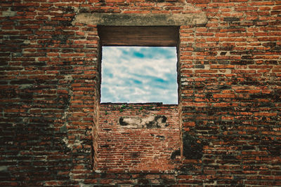 Low angle view of old building against brick wall