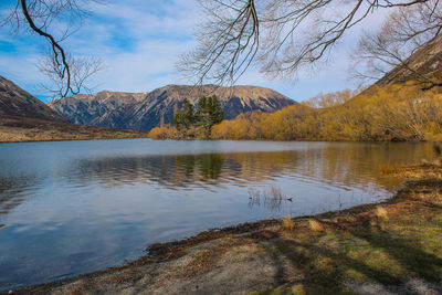 Scenic view of lake by mountains against sky