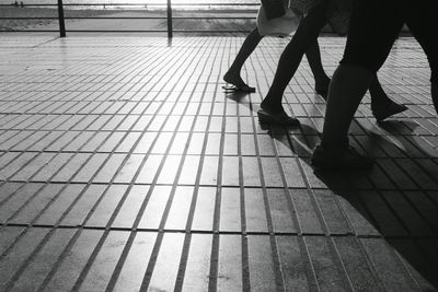Low section of people standing on tiled floor