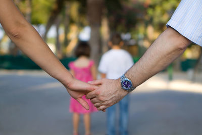 Midsection of couple holding hands