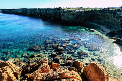 Scenic view of sea against rock formation