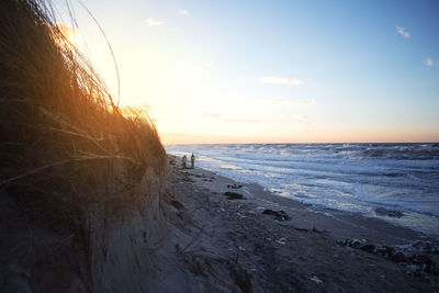 Scenic view of beach against sky during sunset