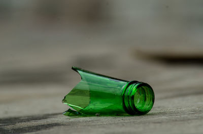 Close-up of green bottle broked on table