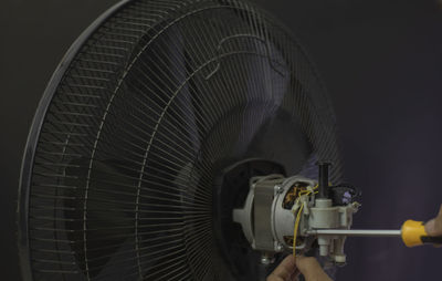 Close-up of electric fan against black background