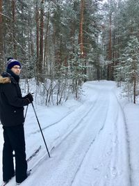 Mid adult man skiing on snow in forest