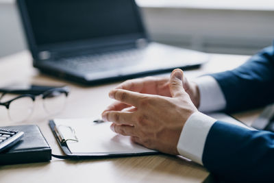 Midsection of man using laptop on table