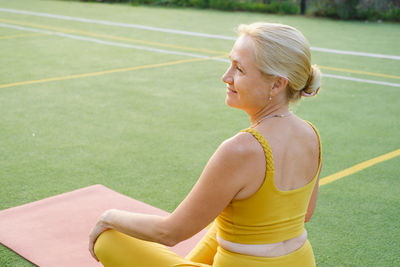 Portrait of young woman standing on field