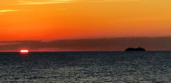 Scenic view of sea against orange sky