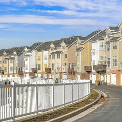 Buildings by road against sky in city