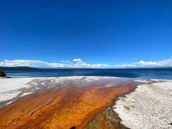 Scenic view of beach against blue sky