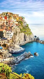 Scenic view of sea by buildings against sky