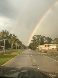 Rainbow over road in city during rainy season