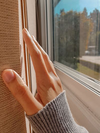 Close-up of woman hand on glass window