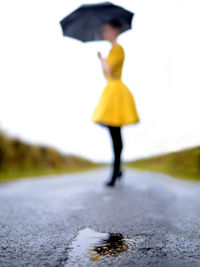 Rear view of woman standing on road