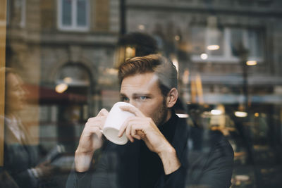 Man holding coffee cup at cafe