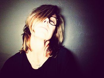 Portrait of smiling young woman against wall