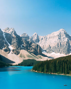 Scenic view of lake and mountains against blue sky