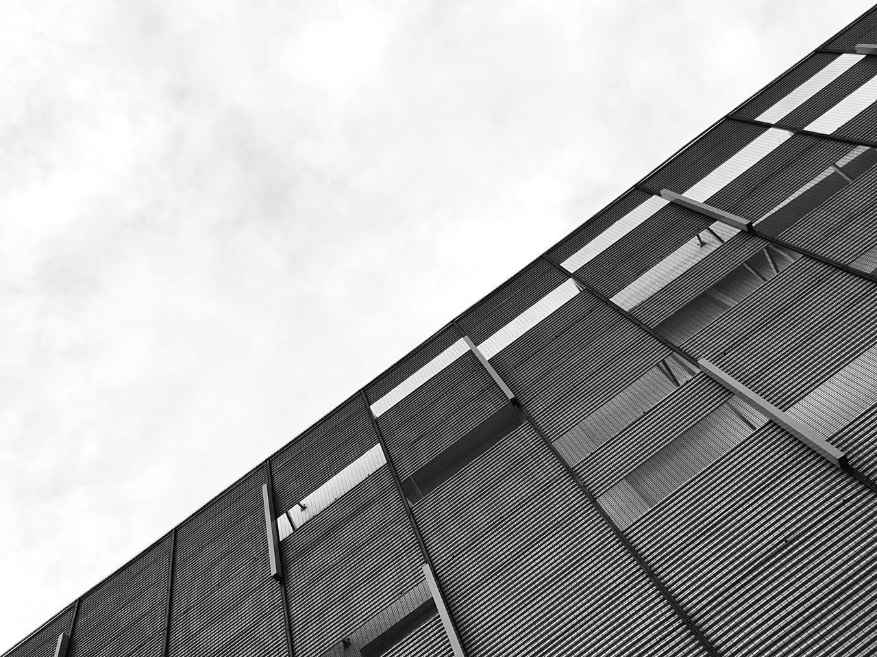 LOW ANGLE VIEW OF GLASS BUILDING AGAINST SKY